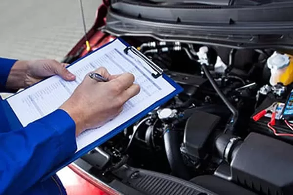 A mechanic filling in a car inspection checklist