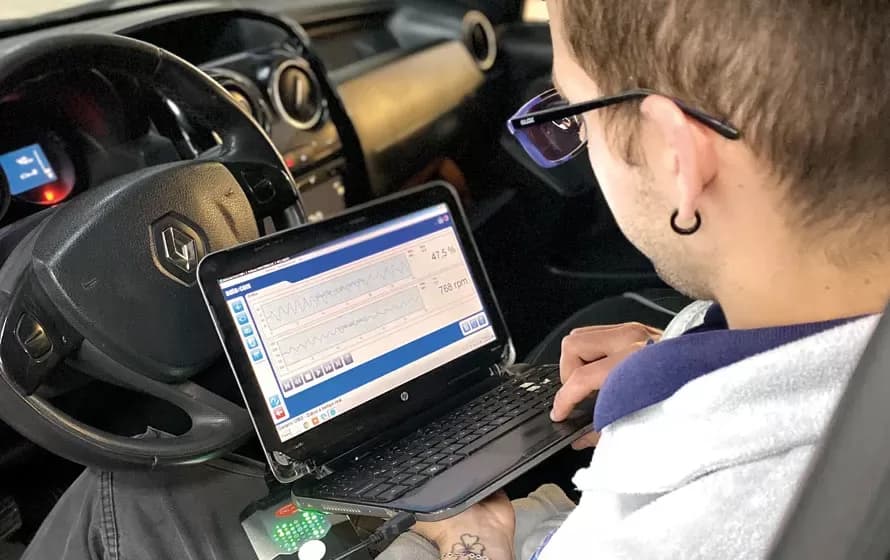 A Qualis mechanic checking a car with the scanner